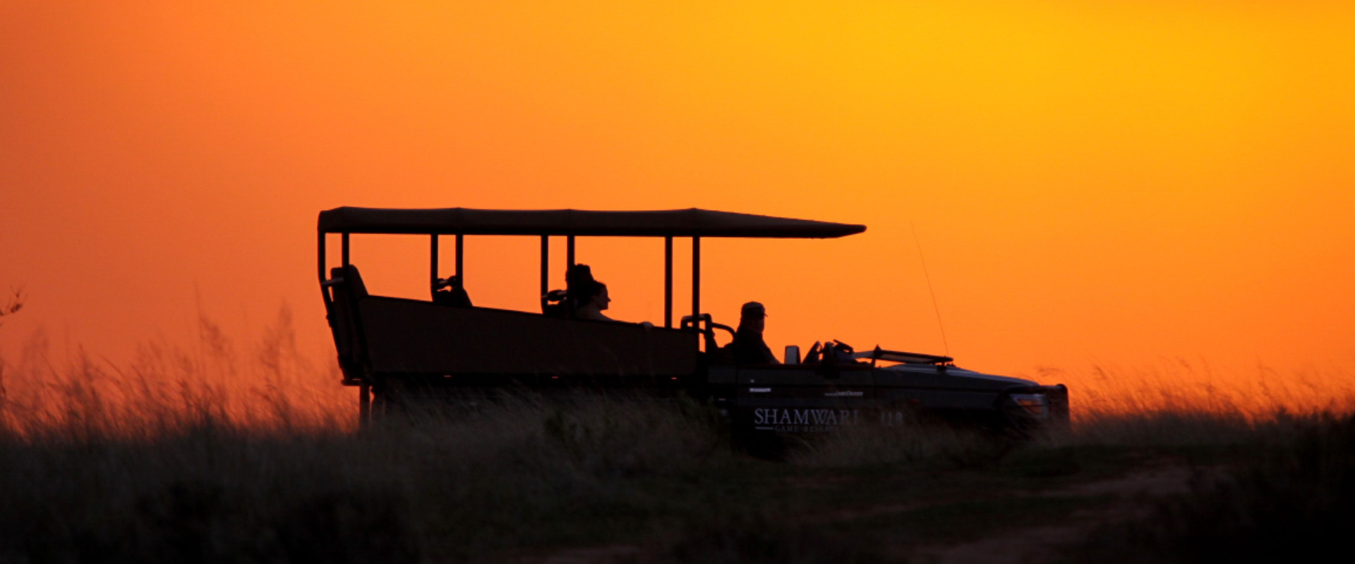 Beba sundowners em uma unidade de jogo do pôr-do-sol