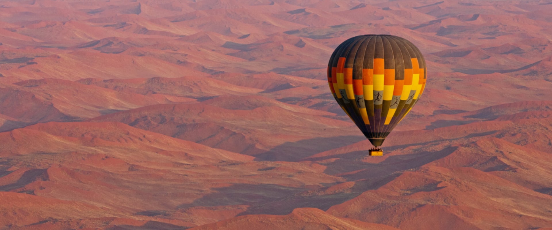 Drift over endless spans of orange dunes in a hot-air balloon